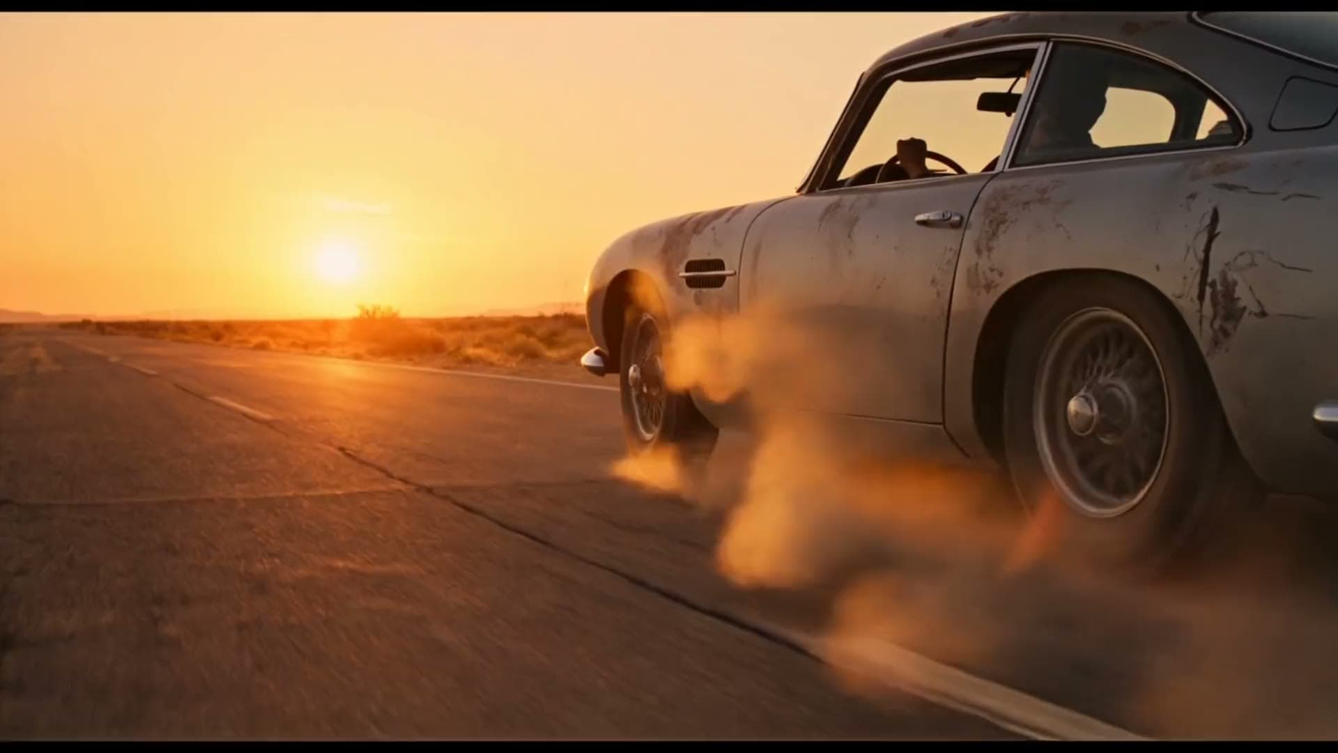 Silver sports car drifting on a desert highway at golden hour